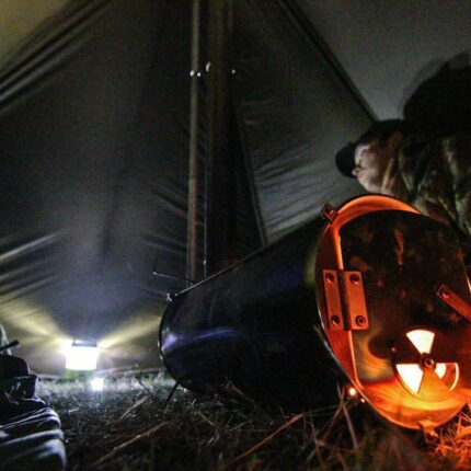A hunter enjoying the heat from a Lite Outdoors small tent stove.